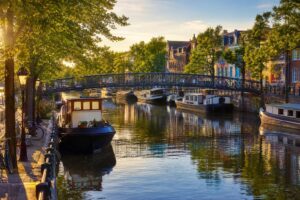 Canal urbain avec péniches amarrées et maisons colorées le long des berges en fin d'après-midi