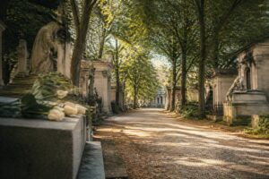 Allée arborée du Père-Lachaise bordée de tombes anciennes en pierre